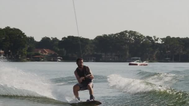 Młody człowiek robi trick na wakeboard — Wideo stockowe