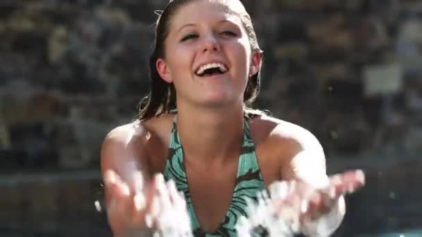 Девушка брызгает водой в бассейне — стоковое видео