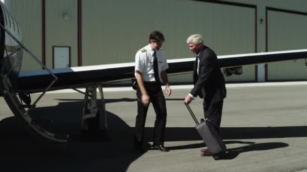 Businessman and pilot shaking hands — Stock Video