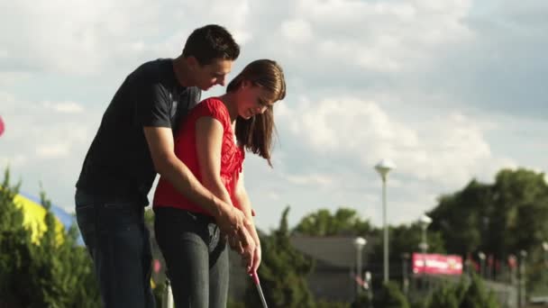 Man vrouw swingende Golfclub onderwijs — Stockvideo