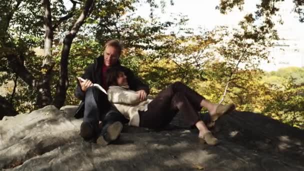 Man läsa boken till kvinna i Central Park — Stockvideo