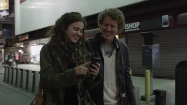 Par med hjälp av mobiltelefon i city — Stockvideo