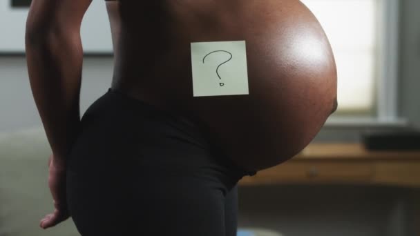 Живот беременной женщины с вопросительным знаком — стоковое видео
