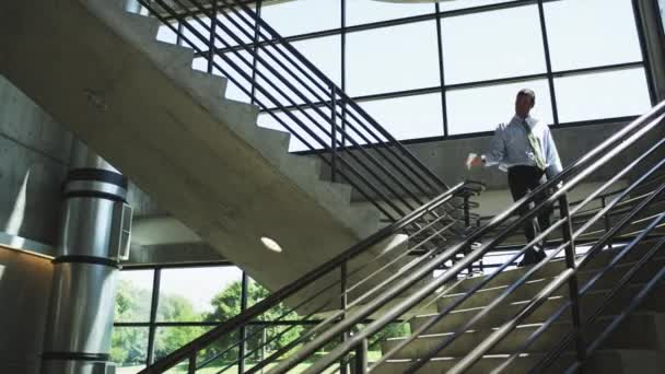 Hombre feliz descendiendo escaleras de oficina — Vídeo de stock