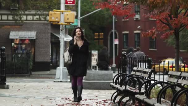 Женщина разговаривает по мобильному телефону на улице — стоковое видео