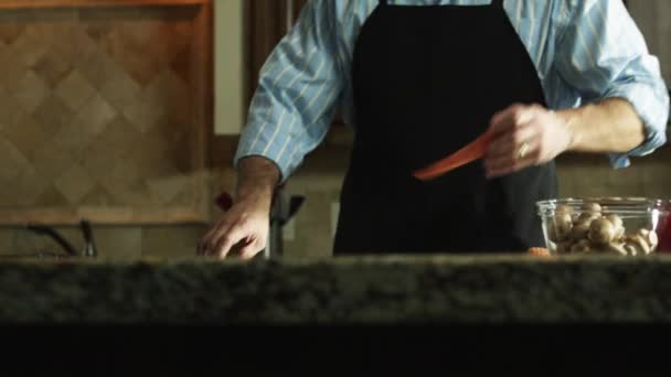 Mann schneidet Möhre in Küche — Stockvideo