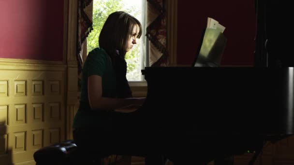Молодая женщина играет на пианино — стоковое видео