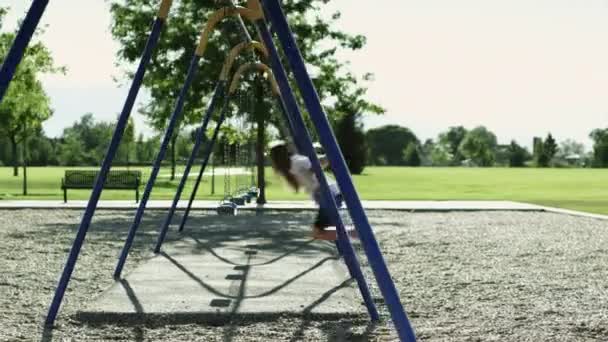 Дівчина на гойдалці в парку — стокове відео