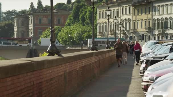 Muž, běhání po římse řeky Arno — Stock video