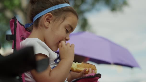 Девочка ест выпечку — стоковое видео