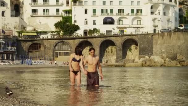 Pareja vadeando en el agua en la playa de Amalfi — Vídeos de Stock