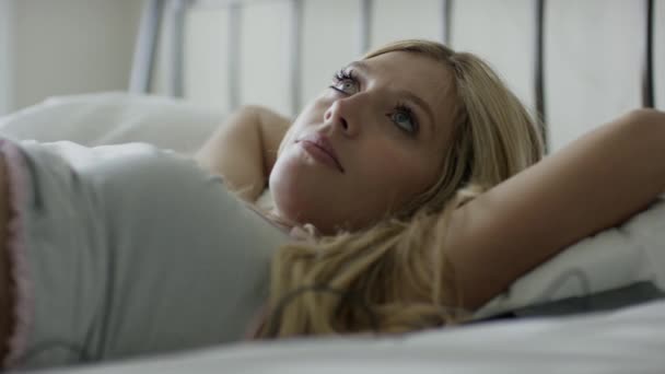 Femme enceinte couchée sur le lit avec écouteurs — Video