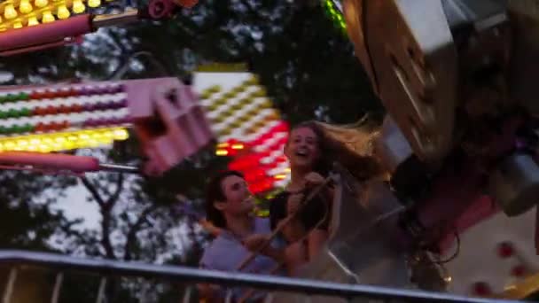 Jovem casal no parque de diversões passeio — Vídeo de Stock