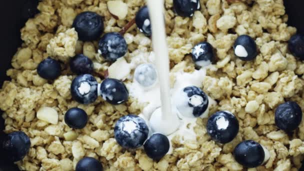 Milch wird in Müsli gegossen — Stockvideo