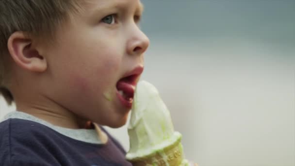 Garçon lécher la crème glacée cône — Video