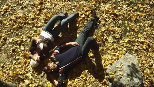 Νεαρό ζευγάρι ξαπλωμένο σε φύλλα — Αρχείο Βίντεο
