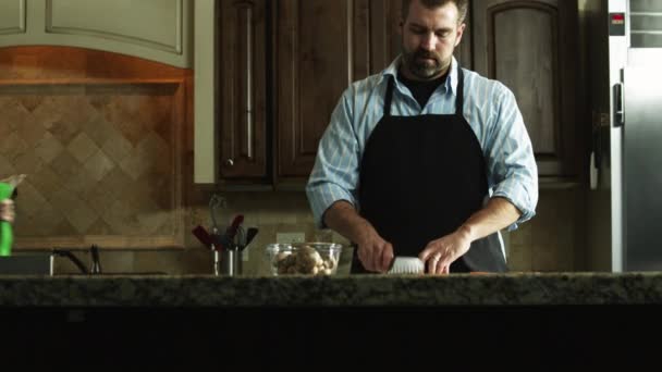 Hombre cortando zanahoria en la cocina — Vídeo de stock