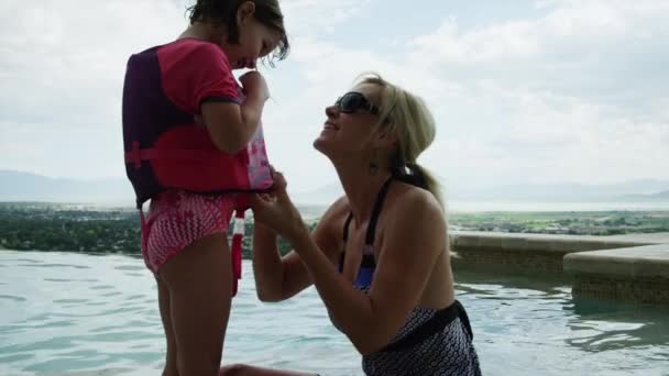 Mutter hilft Tochter, Schwimmweste anzuziehen — Stockvideo