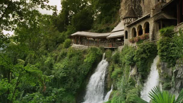 Cascada y edificios en acantilados — Vídeo de stock