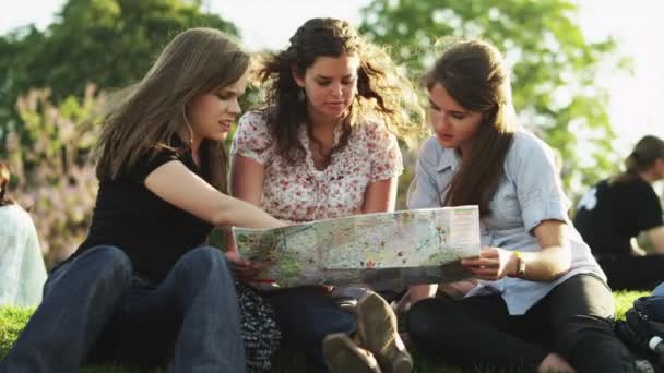 Jonge vrouwen, studeren op kaart — Stockvideo