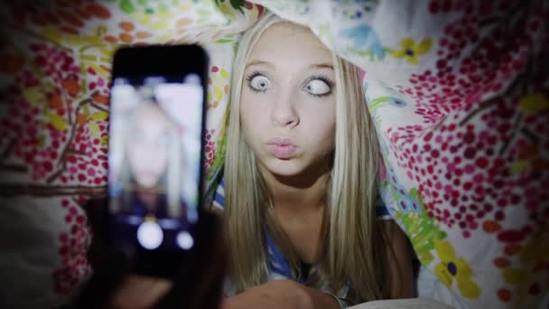 Mädchen nimmt Selbstporträt unter Decke auf — Stockvideo