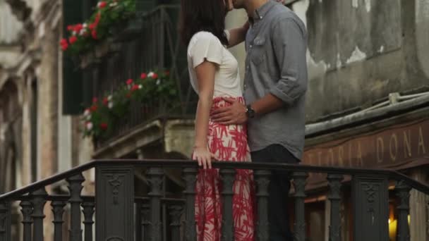Paar küsst sich auf kleiner Bogenbrücke — Stockvideo