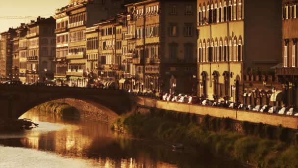 Riverbank y puente de arco al atardecer — Vídeos de Stock