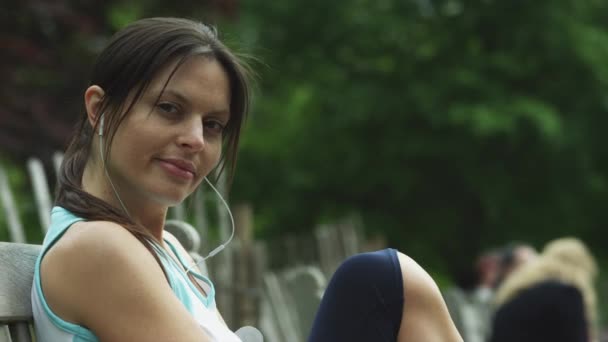 Жінка сидить на лавці в парку — стокове відео