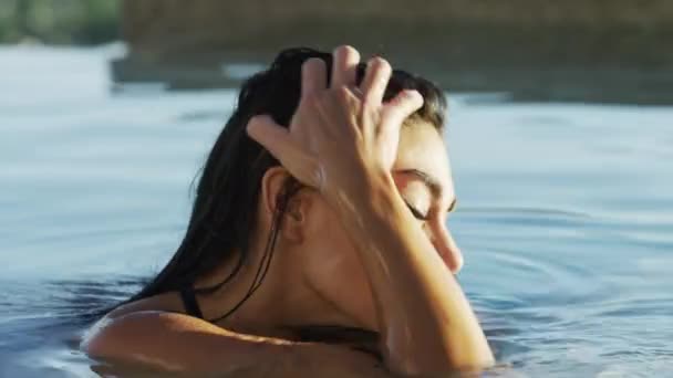 Woman fixing hair in swimming pool — Stock Video