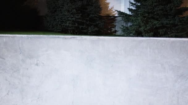 Скейтбордист катается в скейтпарке по ночам — стоковое видео