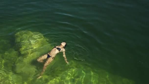 Junge Frau schwimmt im See — Stockvideo