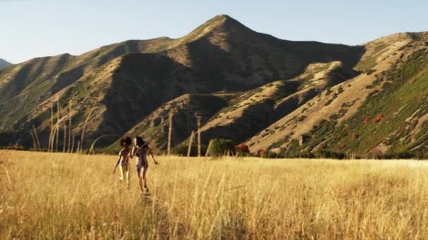 Duas adolescentes correndo pelo campo — Vídeo de Stock