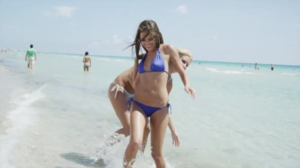 Mujeres jóvenes jugando en la playa — Vídeo de stock
