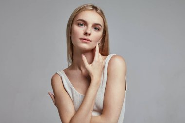 Gri arka planı olan bir kadının stüdyo çekimi.