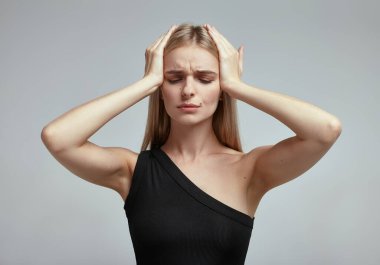 Gri arka planı olan bir kadının stüdyo çekimi.