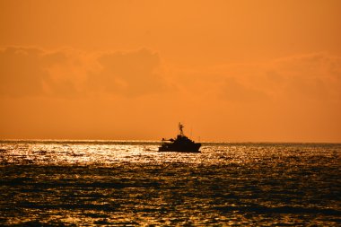Denizdeki bir teknenin silueti