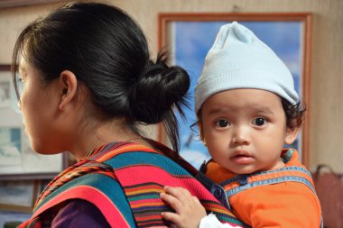 Chichicastenango Gustemala 29 Nisan 2016: Annesinin sırtında bir Maya bebeğinin portresi taşıdı. Maya halkı hala Guatemala 'daki nüfusun çoğunluğunu oluşturuyor.,
