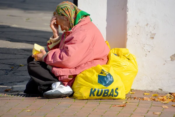 SIAULIAI LITHUANIA 09 17 2015: Poor old woman asking for money at the exit of a Church. Lithuania Population below poverty line 4% (2008)