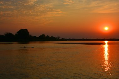 Sakin su yüzeyi üzerinde renkli günbatımı.