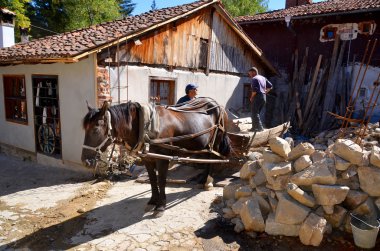 KOPRIVSHTITSA BULGARIA 25 Eylül: Erkekler, 25 Eylül 2013 tarihinde Koprivshtitsa Bulgaristan 'da bir atın yardım ettiği eski evleri restore ediyorlar