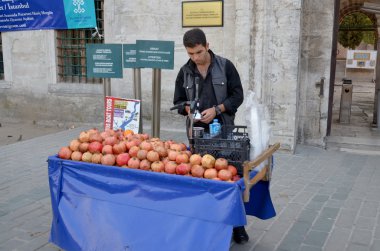 İSTANBUL TURKEY SEPT 28 Eylül 2013: Genç adam 28 Eylül 2013 tarihinde İstanbul 'da yaşamak için nar suyu satıyor. Nar suyu Türkiye 'de en popüler olanlardan biri.