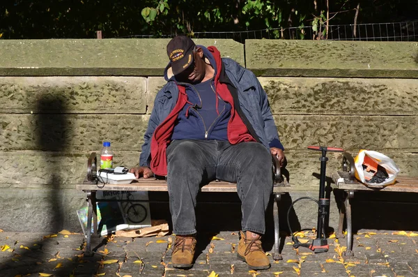 アフリカの酔った男が街のベンチで寝ている — ストック写真