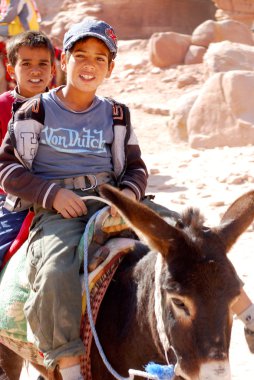Petra-Ürdün 25 Numara: Kimliği belirsiz çocuklar 25 Kasım 2009 Petra, Ürdün 'de eşeğe binmek için turist arıyor. Yolculuk 20 jd tuttu. Petra, Nabataean krallığının etkileyici başkentiydi..