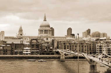LONDON JUNE 2 :People walking across a footbridge Millennium Bridge. Background is St Paul's cathedral in London. Bridge was opened 10 June 2000. View on June 2, 2012