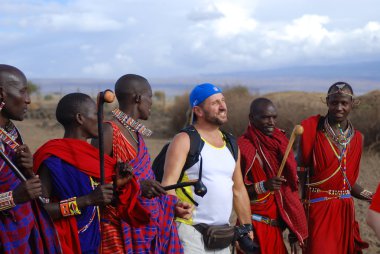 AMBOSELI, KENYA - 13 Ekim 2011 'de Amboseli, Kenya' da düzenlenen geleneksel bir gösteri sırasında Masai kabilesinden kimliği belirsiz Afrikalı bir grup turistle dans etti. Onlar göçebe ve köylerde yaşıyorlar..
