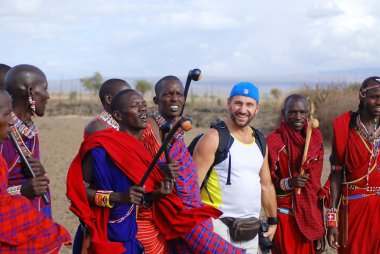 AMBOSELI, KENYA - 13 Ekim 2011 'de Amboseli, Kenya' da düzenlenen geleneksel bir gösteri sırasında Masai kabilesinden kimliği belirsiz Afrikalı bir grup turistle dans etti. Onlar göçebe ve köylerde yaşıyorlar..