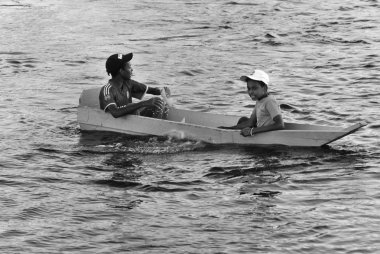 KARNAK EGYPT-NOV. 28: Unidentified young boys float on a styrofoam plate on the nile river near Karnak Egypt on Nov. 28, 2009.Nubian boys chase tourist boats to sing and ask for some money.