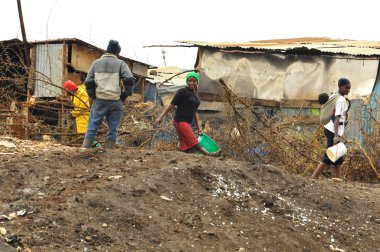NAIROBI, KENYA-OCT. 13: Unidentified kid walk in mud through the Nairobi slum Oct. 13 2011 in Nairobi, Kenya. Kibera is the largest slum in Nairobi, and the second largest urban slum in Africa