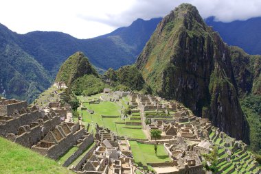 Machu Picchu ya da Machu Pikchu Quechua machu yaşlı, yaşlı, pikchu piramidi; dağ ya da geniş tabanlı ve keskin tepelerle biten bir çıkıntı