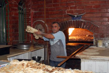 AMMAN - JORDAN NOVEMBER 27: Man make pita breads in typical brick wood oven on November 27, 2009 Amman, Jordan. Pita bread is a type of flat bread common in Middle Eastern cuisines.